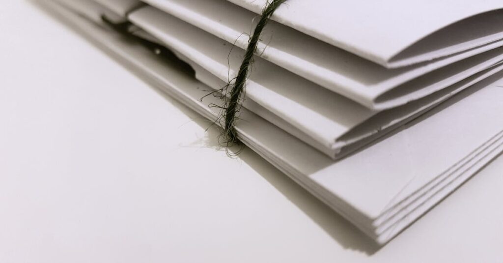 Pile of white envelopes tied with a green string, showcasing a minimalist design.