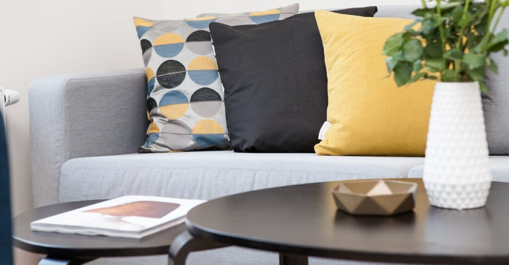 Contemporary living room interior featuring a stylish sofa, decorative pillows, and a vase of flowers.