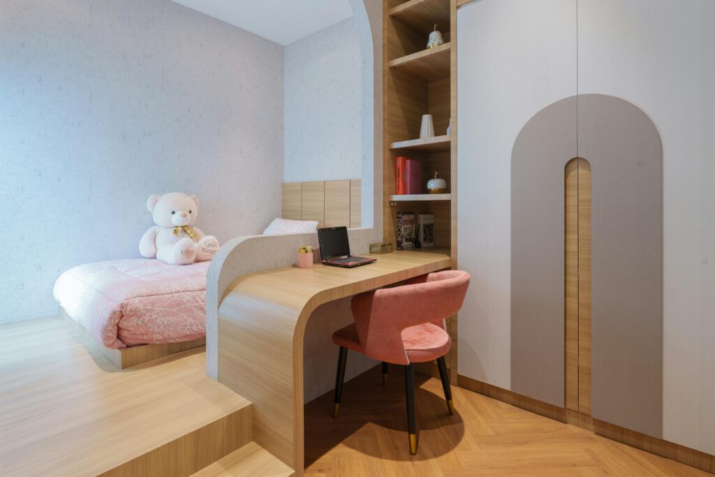 Warm and cozy children's bedroom with a desk and large teddy bear in Jakarta, Indonesia.