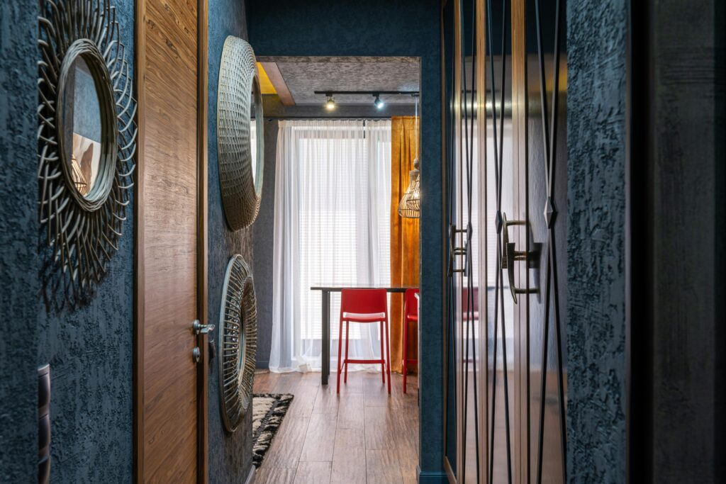 Elegant indoor corridor with stylish decor, colorful chairs, and natural light.