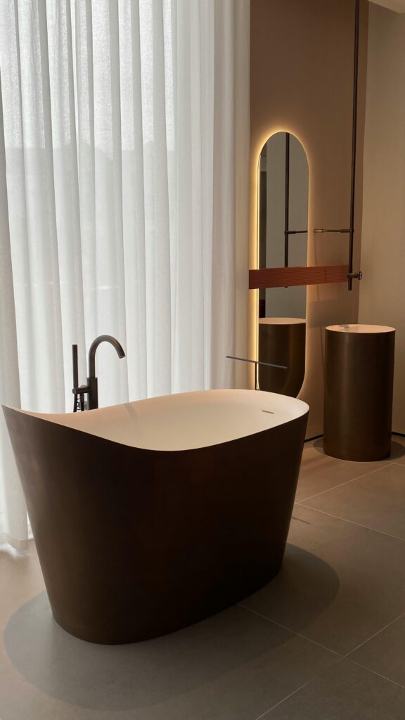 Sleek modern bathroom showcasing a freestanding tub with minimalist design elements and soft lighting.
