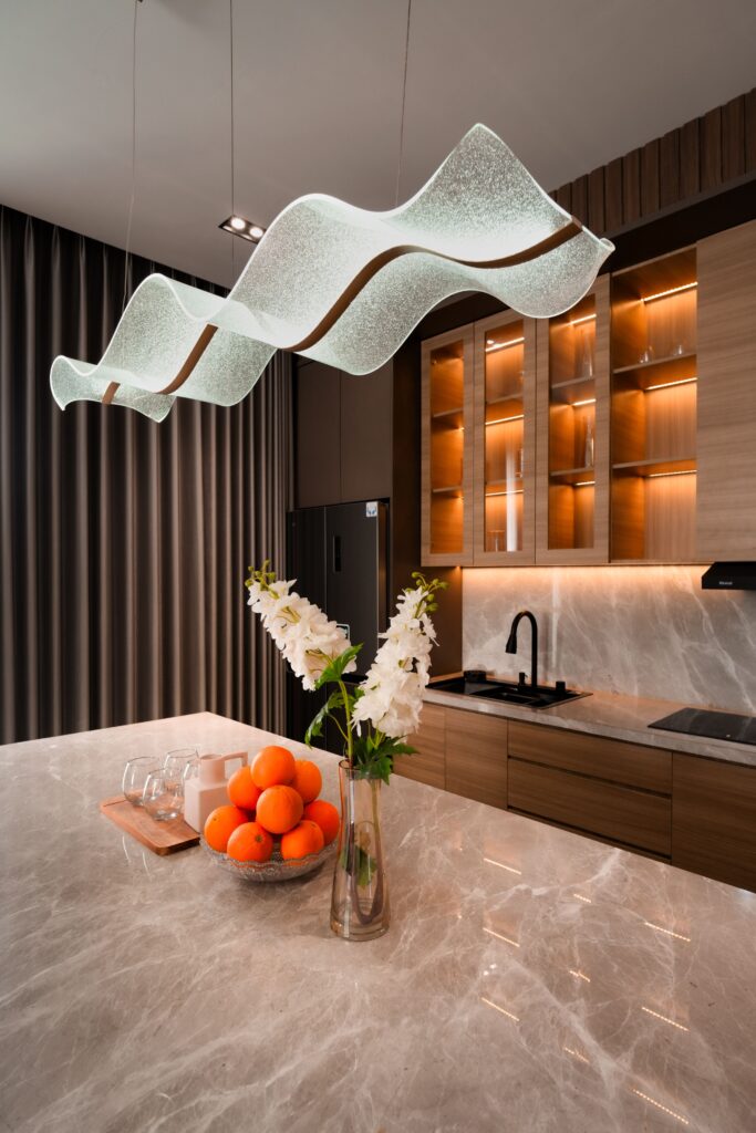 A sleek, contemporary kitchen in Jakarta highlighted by elegant lighting and marble countertops. Cucina di lusso
