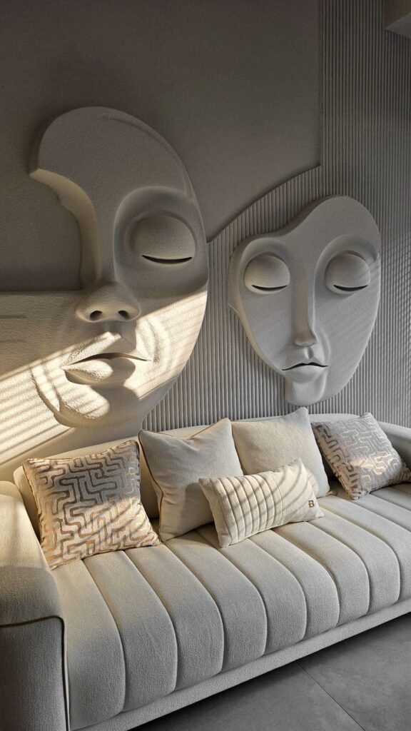 Stylish modern living room with artistic face sculptures above a plush sofa.