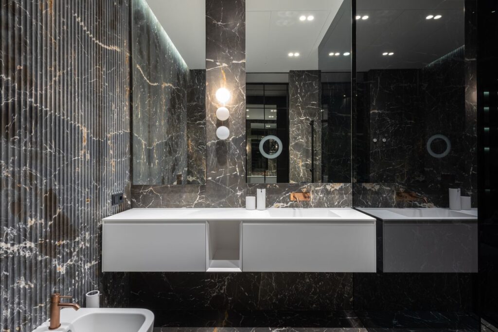 Interior design of modern stylish bathroom with big mirrors and white ceramic tub near sink