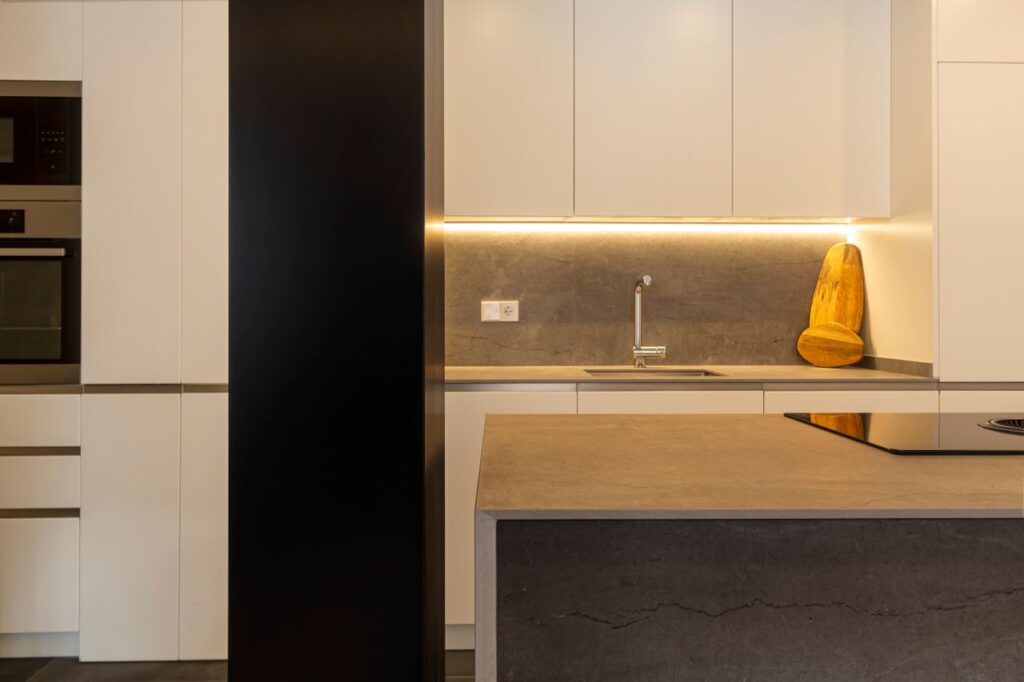 A stylish kitchen featuring modern design with minimalist elements and warm lighting.
