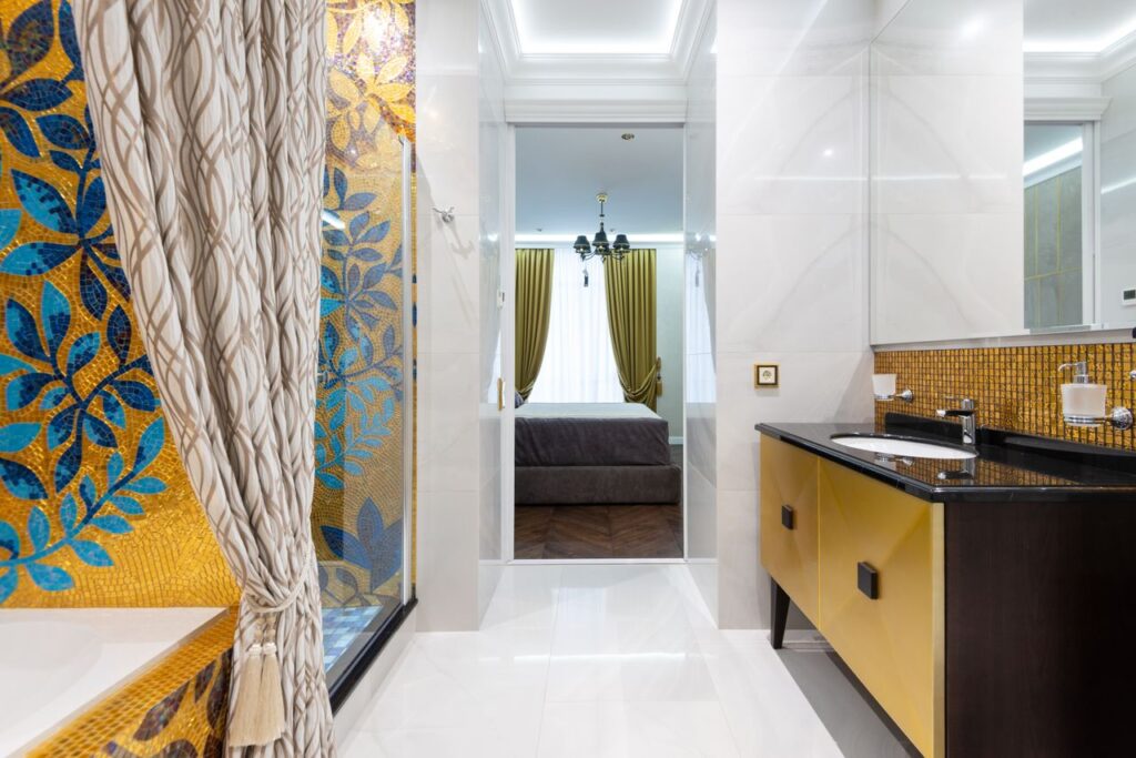 Luxury bathroom with mosaic art leading to a cozy bedroom, showcasing modern interior design. Arredamento contemporaneo
