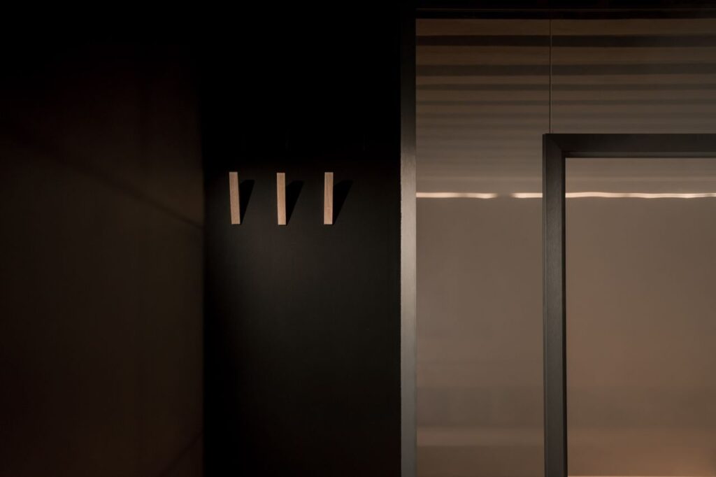 A minimalist interior design featuring sleek wall hooks and subtle lighting, capturing modern simplicity.