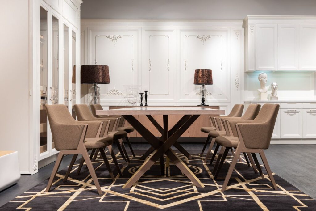 Contemporary table with set of chairs placed on rug in spacious kitchen with white cupboards and classic design at home, Soggiorno classico contemporaneo.