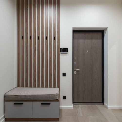Interior of modern spacious hall with wooden cabinet with desks placed in corner and big mirror in apartment, Cappottiera da ingresso