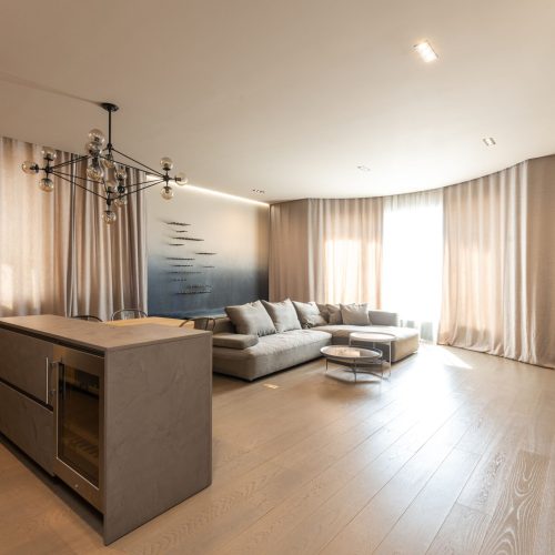 Interior of modern apartment with counter placed near comfortable sofa at decorated wall and window with curtains at home with TV, ristrutturazione trilocale